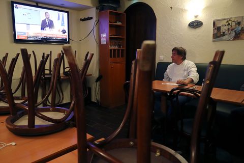 French chef and restaurant owner Alain Fontaine watches a news channel on a television set in his restaurant "Le Mesturet" on Thursday, May 28, in Paris as French Prime minister annouces updated lockdown measures to curb the spread of the COVID-19 disease caused by the novel coronavirus. 
