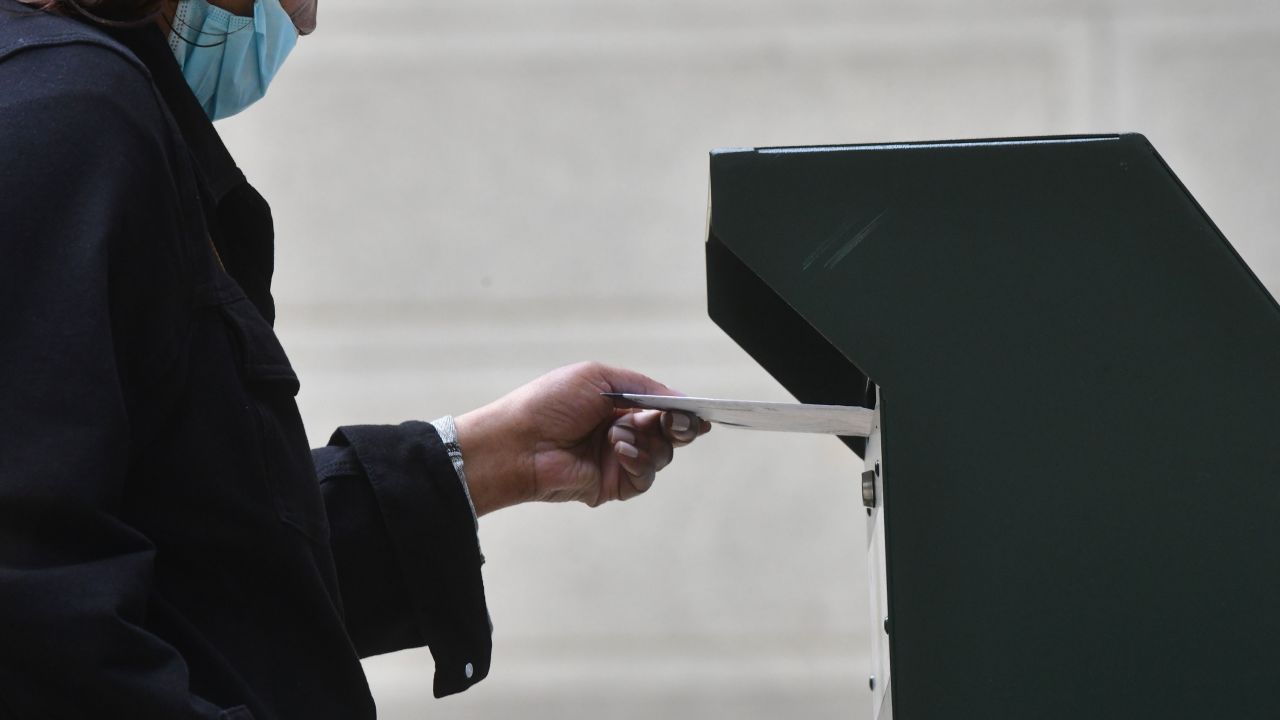 A woman deposits her ballot in an official ballot drop box on October 27 in Philadelphia, Pennsylvania. 