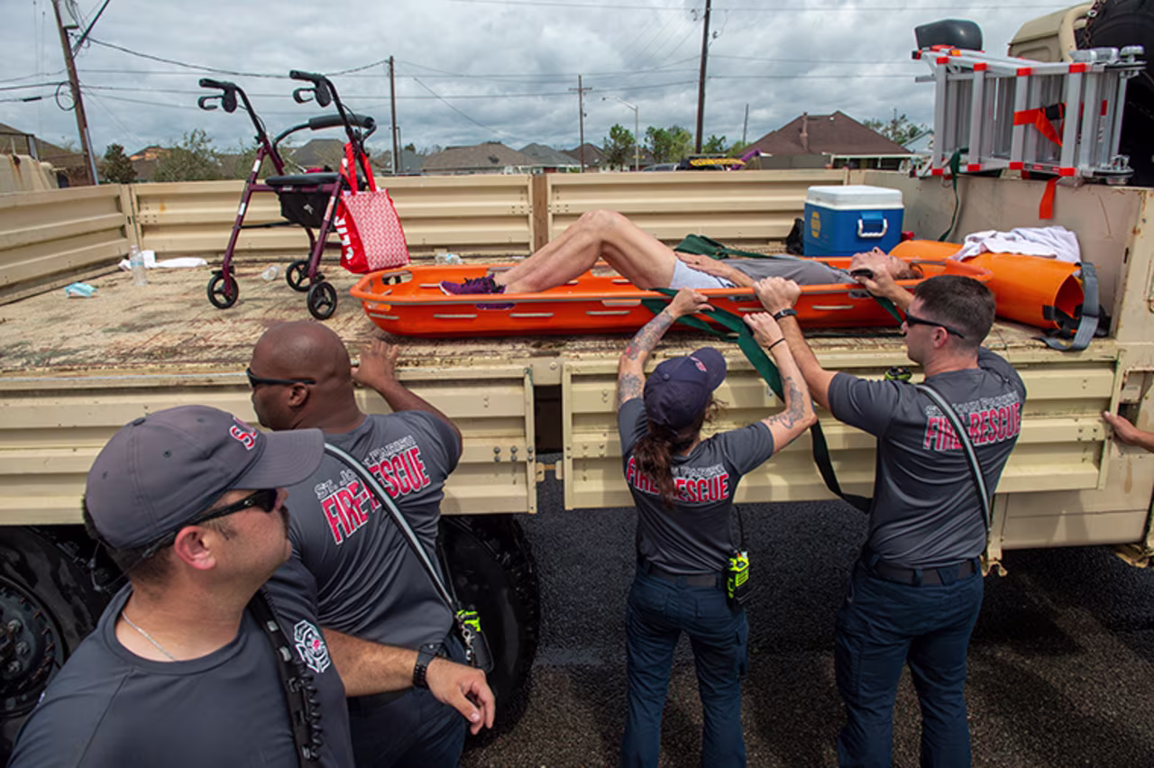 St. John the Baptist Parish rescue teams place a person onto the back of a truck during an evacuation on the morning after Hurricane Ida hit the area, Monday, August 30, in St. John the Baptist Parish, Louisiana. 