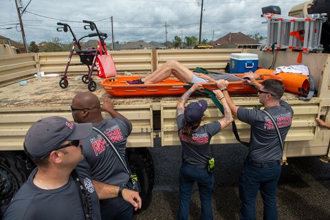 St. John the Baptist Parish rescue teams place a person onto the back of a truck during an evacuation on the morning after Hurricane Ida hit the area, Monday, August 30, in St. John the Baptist Parish, Louisiana. 