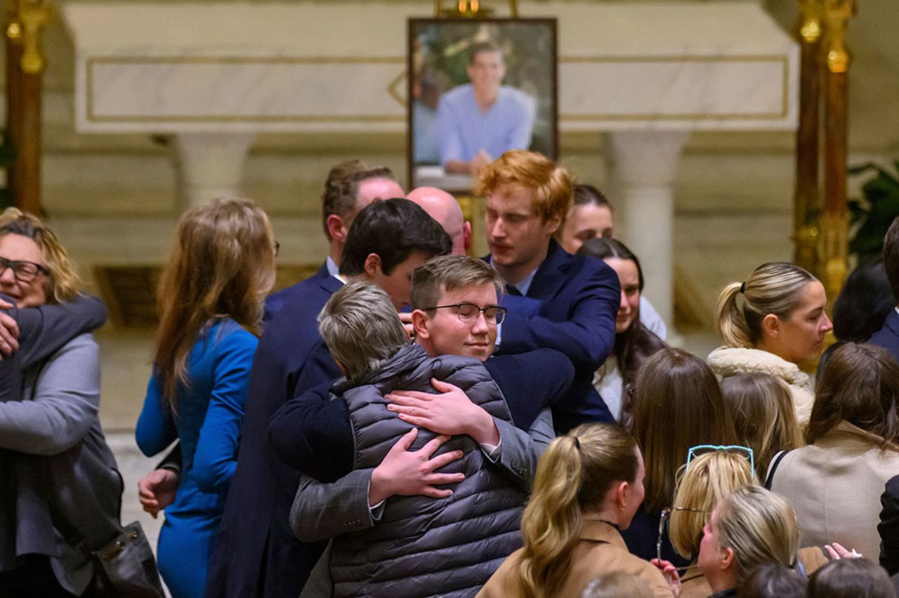 Friends and supporters console each other during a memorial service for Brian Fraser in Grosse Pointe Farms, Michigan, on Tuesday, February 14.