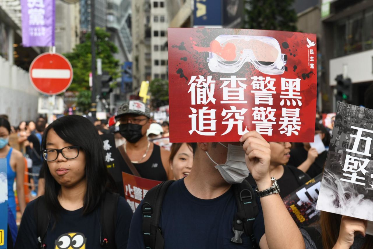 Protesters hold signs as part of a pro-democracy march in Victoria Park on August 18, 2019. 