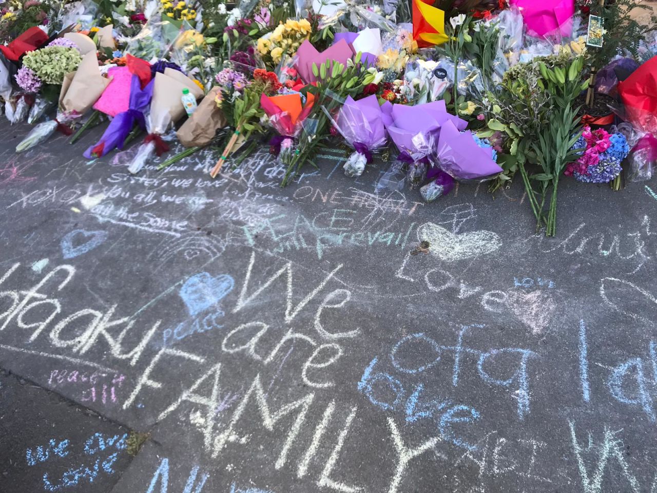 Notes in chalk and flowers are seen outside the Al Huda mosque.