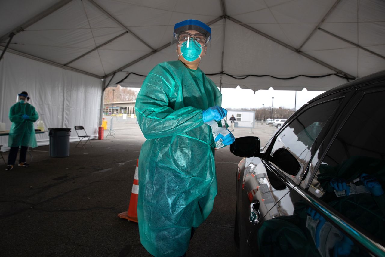 A doctor from SOMOS Community Care prepares to test a patient at a drive-through testing center at Lehman College in New York City on March 28.