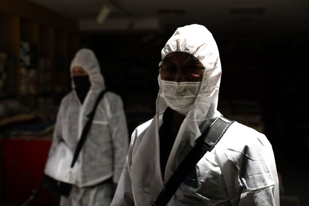 Disinfection workers spray antiseptic solution to guard against the coronavirus at a department store in Seoul, South Korea today.