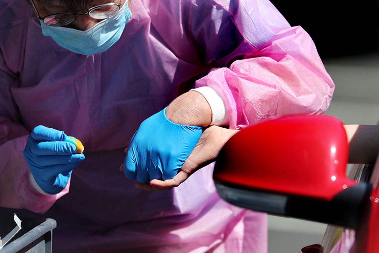 A staff member at the Stanford Radiology department takes a blood sample during a coronavirus antibody study at Mountain View's First Presbyterian Church in Mountain View, California, on Friday, April 3. 