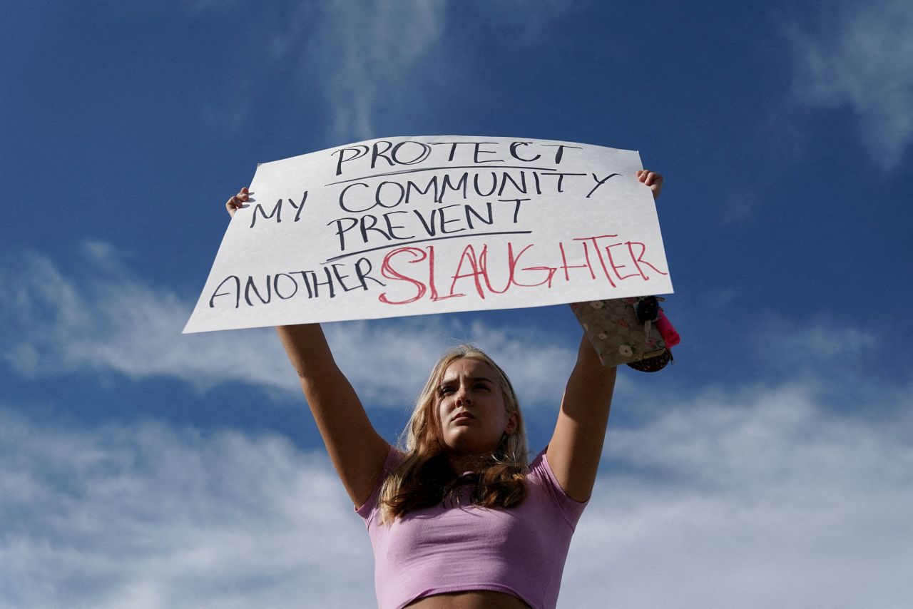 Student Gretchen Gierlach, 18, holds up a sign following the shooting.