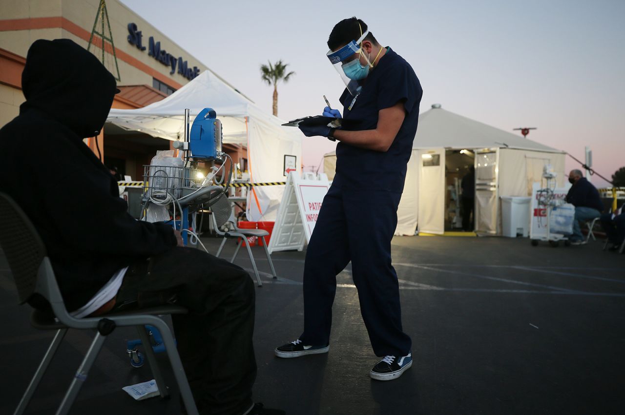A California National Guard medic checks the vital signs of an incoming patient in front of triage tents set up outside Providence St Mary Medical Center amid a surge in Covid-19 patients in Southern California on December 18, in Apple Valley, California. 