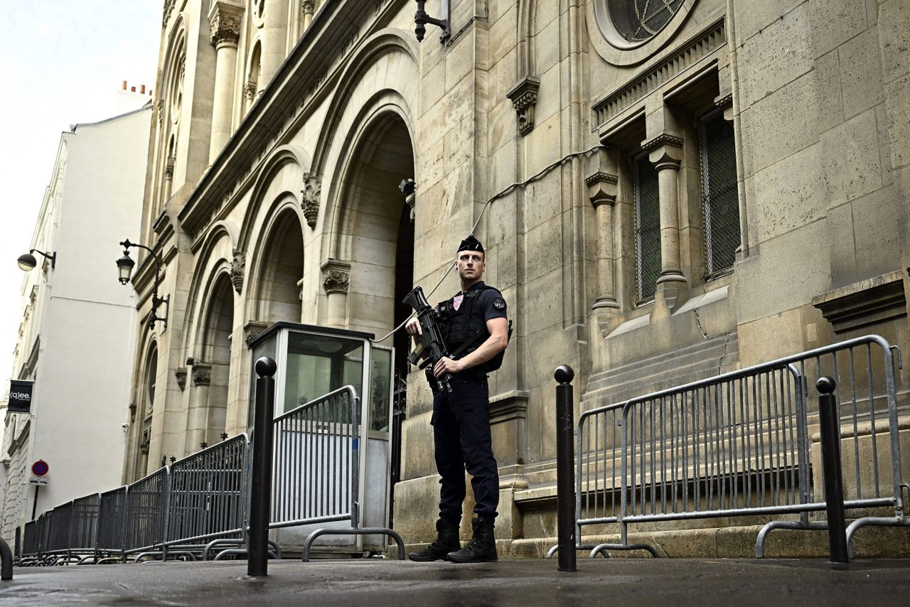 A French riot policeman stands guard outside the Paris Synagogue after security measures have been reinforced near Jewish temples and schools in central Paris, France, on October 9.