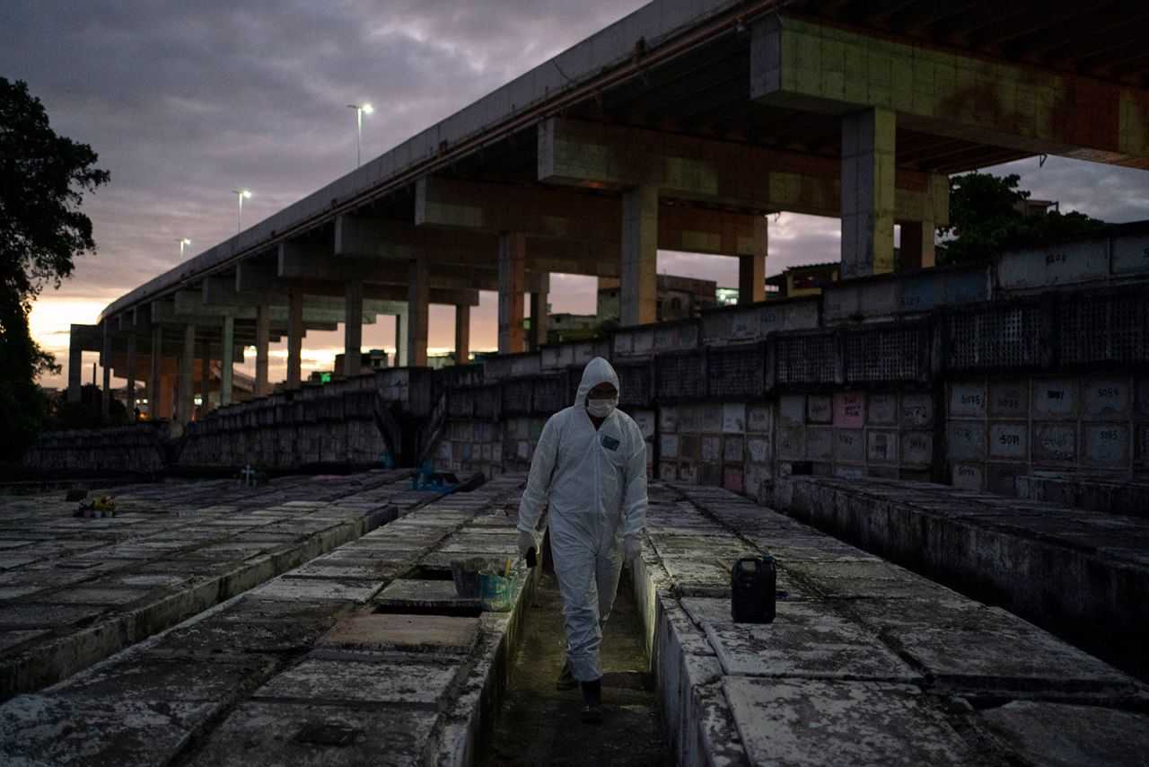 Cemetery worker Bruno Avelino walks through a graveyard in Rio de Janeiro, Brazil, on Friday, May 8.