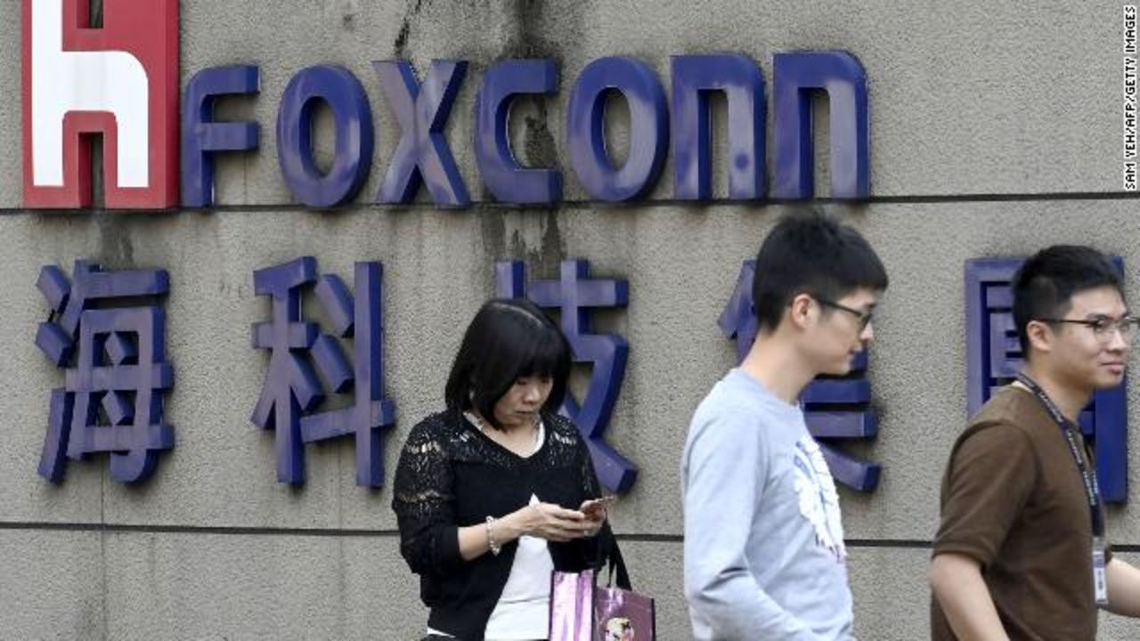 People walking past a Foxconn sign in Taipei in January 2019.?