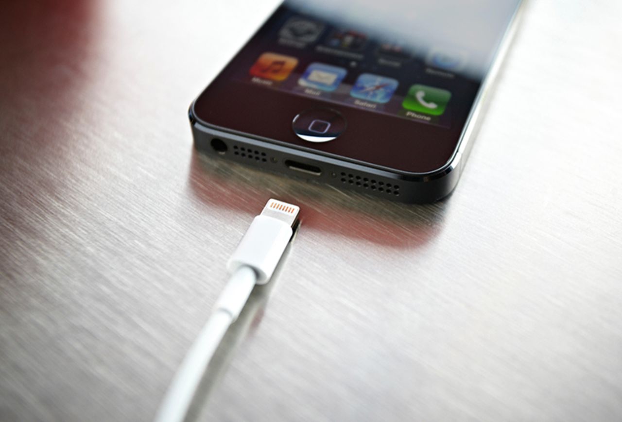 A newly released Apple iPhone 5 sits on a coffee shop countertop next to Apple's lightning connection cable in September 2012.