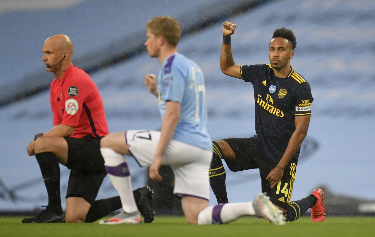 Arsenal's Pierre-Emerick Aubameyang, right, takes a knee in support of the Black Lives Matter movement prior to a match against Manchester City at the Etihad Stadium in Manchester, England, on June 17.