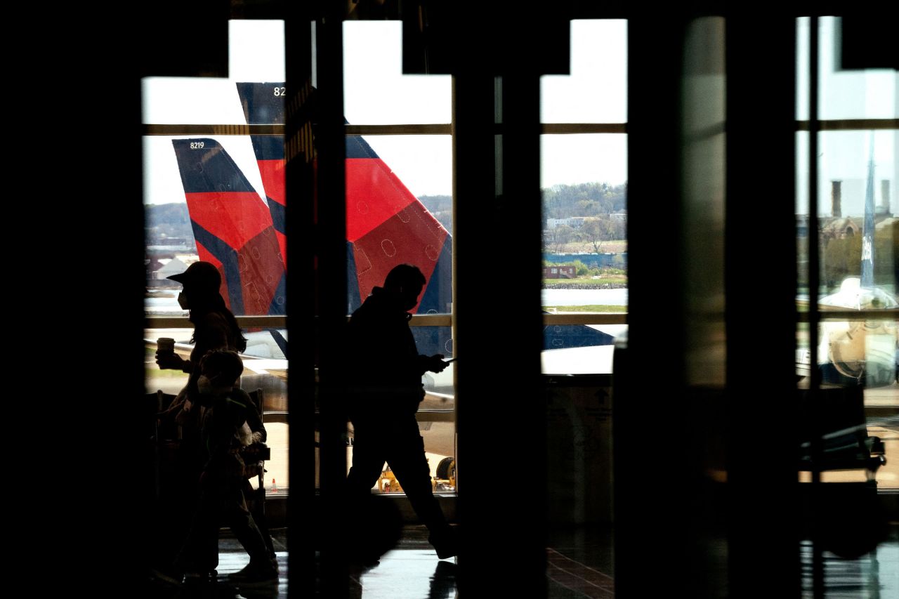 Delta Airlines jets are seen behind travelers passing through Ronald Reagan Washington National Airport in Arlington, Virginia, on April 11.