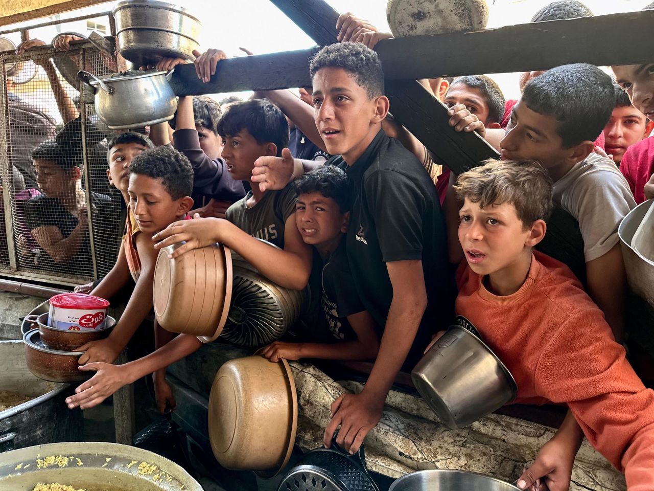 Children queue to receive food aid from a charity organization in Rafah, on May 3. 
