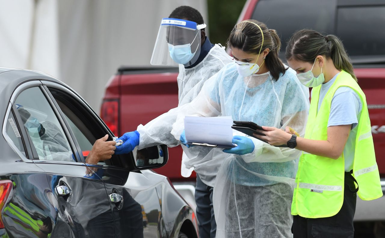 Health care workers greet people as they arrive at a temporary drive-through COVID-19 testing site at East Orange District Park on October 1 in Orlando.