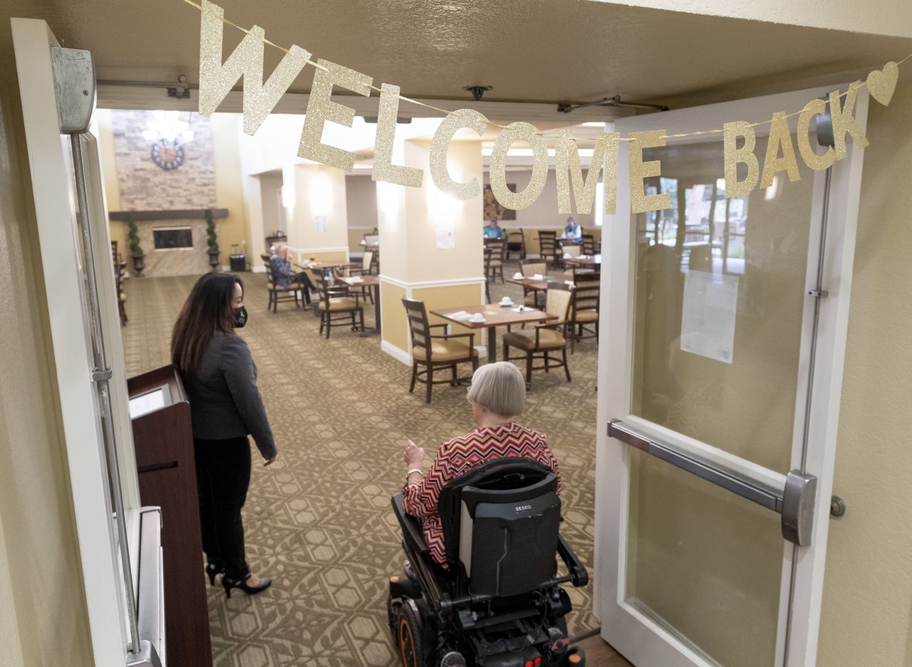 Executive Director Patricia Gustin greets residents entering the dining room at a nursing home in Anaheim, California, on March 8. 