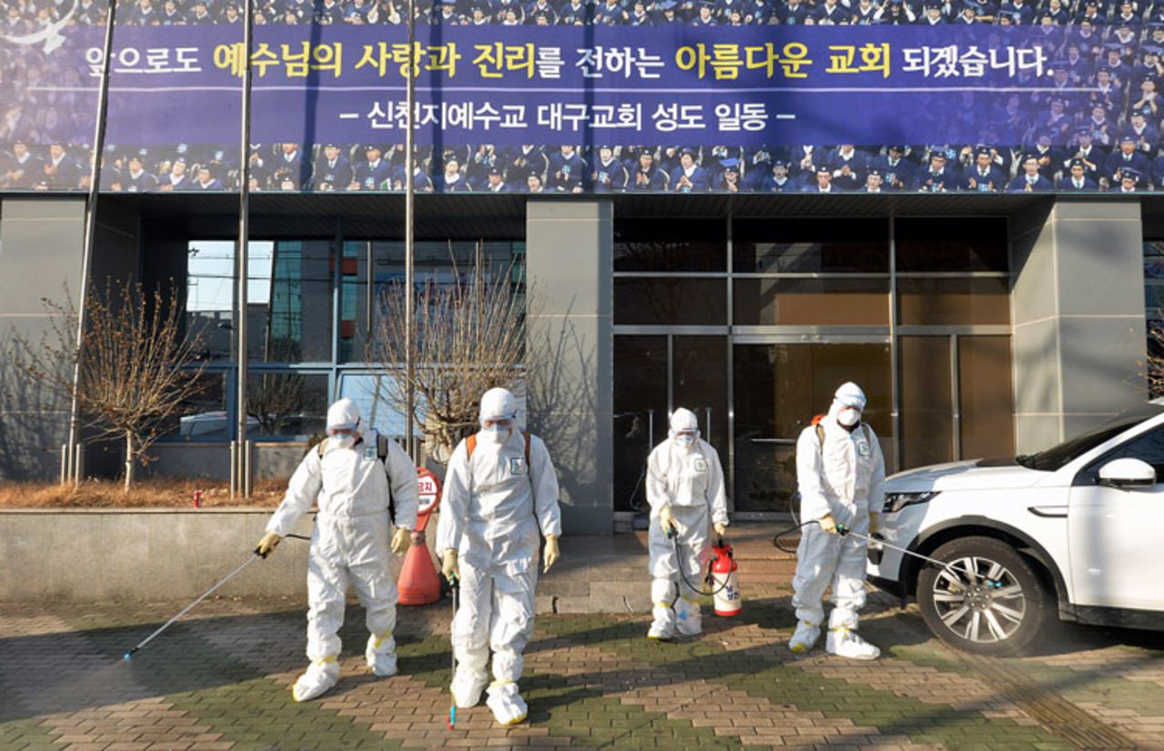 Workers wearing protective gear spray disinfectant against the coronavirus in front of a church in Daegu, South Korea, on Wednesday, February 19.