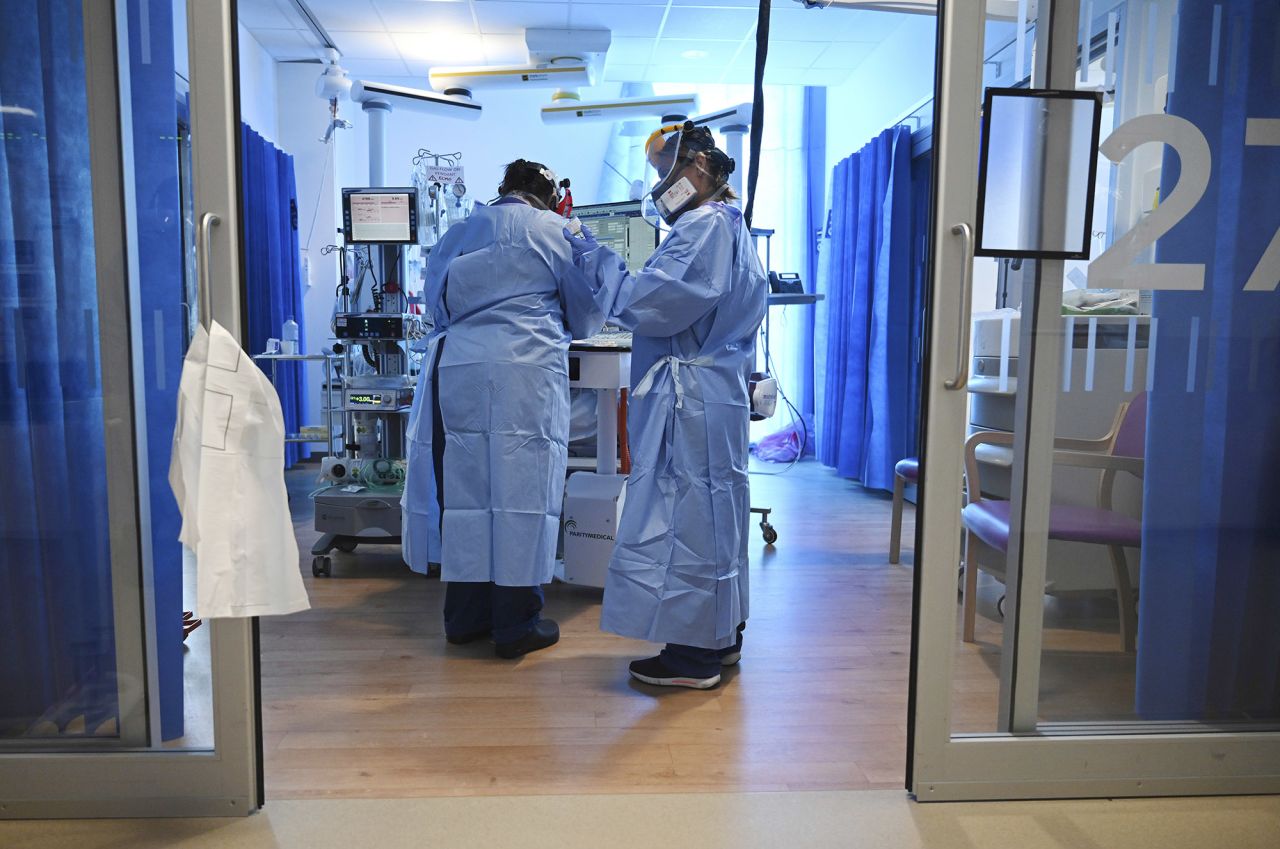 Health care providers wearing personal protective equipment (PPE) care for a patient with coronavirus at the Royal Papworth Hospital in Cambridge, England, on Tuesday, May 5. 