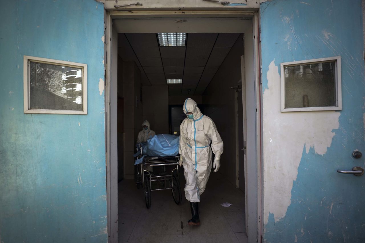 Medical workers move a person who died from the novel coronavirus at a hospital in Wuhan on Sunday.