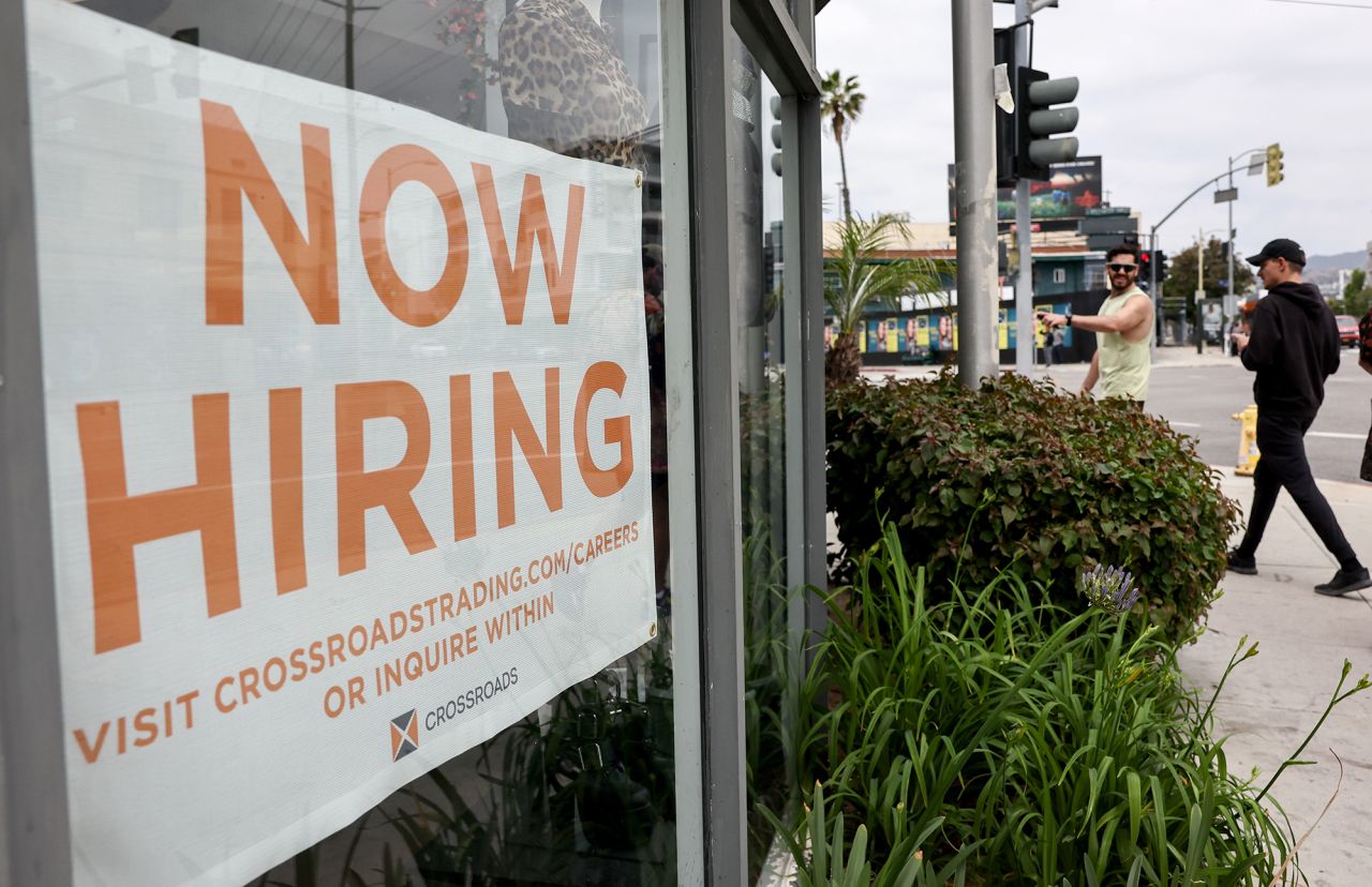 A 'Now Hiring' sign is displayed outside a resale clothing shop on June 2, 2023 in Los Angeles, California. 