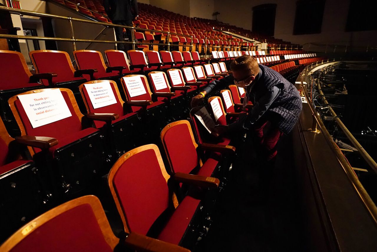 A member of the production staff puts labels on seats in an effort to keep seats socially distanced ahead of the vice presidential debate at the University of Utah, On Wednesday in Salt Lake City. 