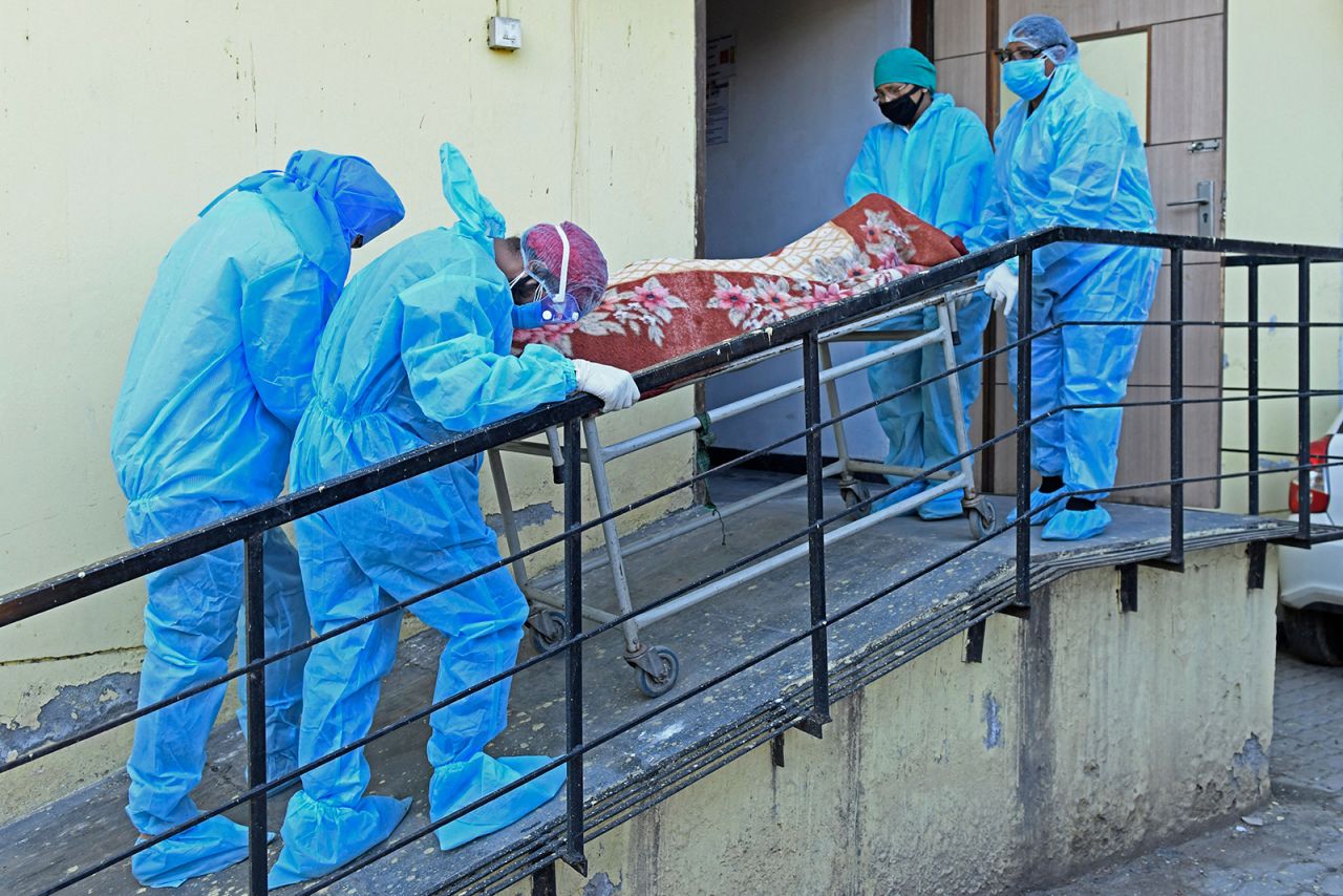 Members of medical staff wearing protective gear carry the dead body of a Covid-19 victim at a hospital in Amritsar, India on April 24.