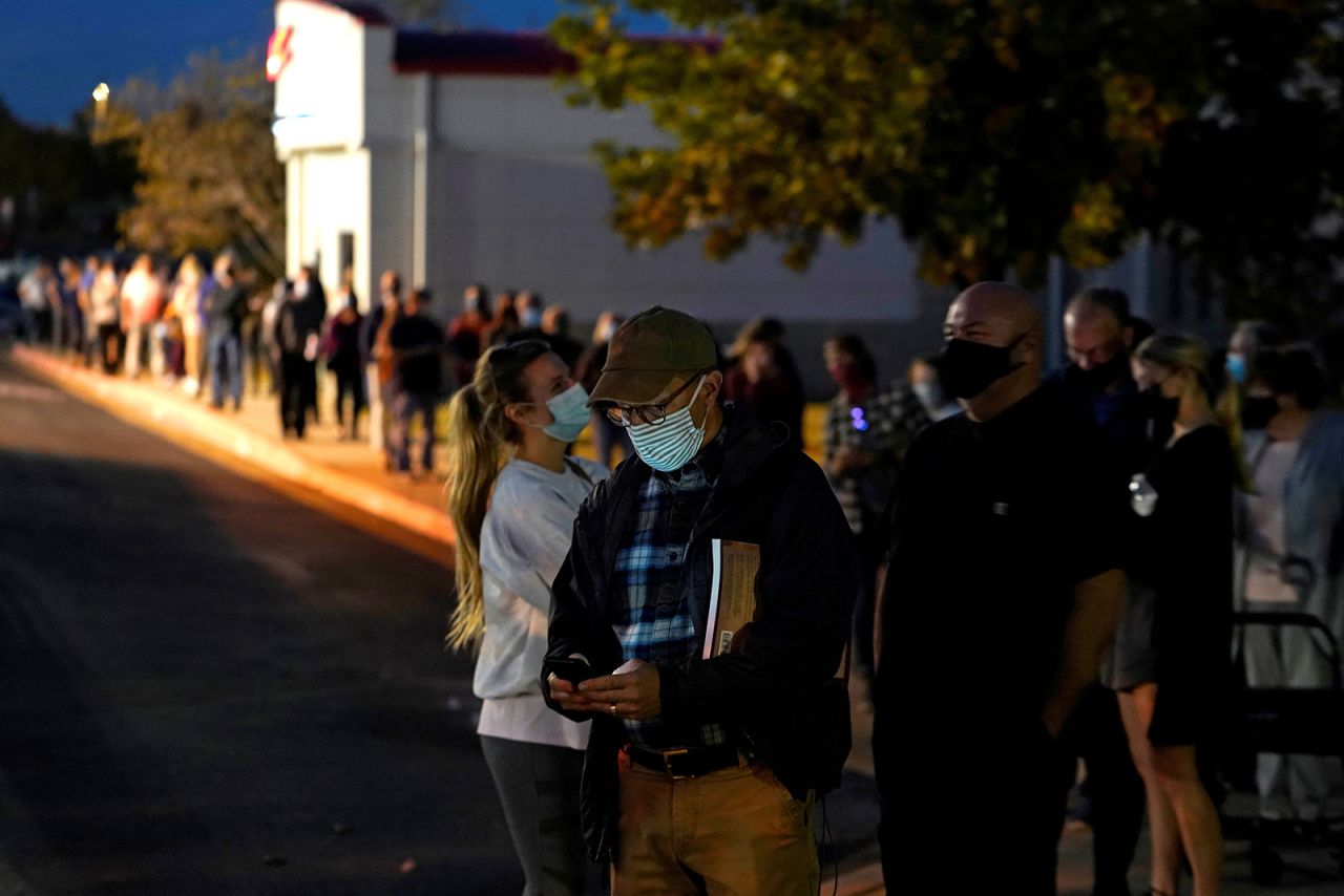 Voters wait in line at sunset to cast their ballots for the 2020 U.S. presidential election at Life.Church in Edmond, Oklahoma on Tuesday. 