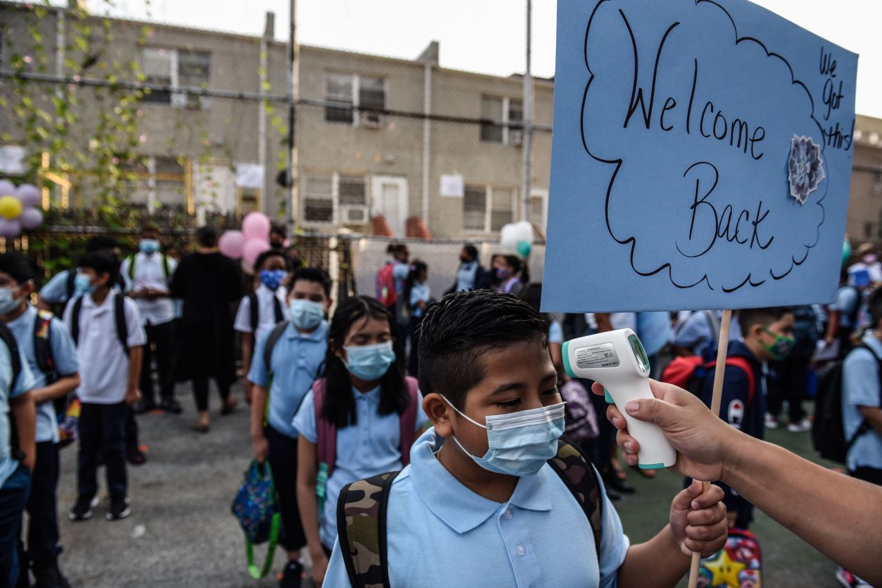 Students wait in line to get their temperature taken before entering a public school in the Bronx on September 13.