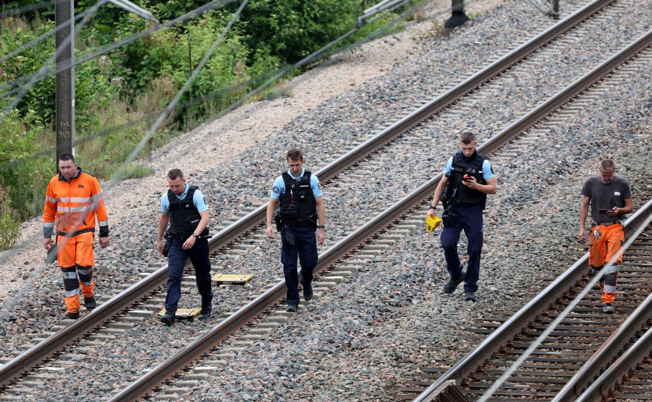 SNCF employees and French gendarmes inspect the scene of a suspected attack on the high speed railway network at Croiselles, northern France, on July 26. 