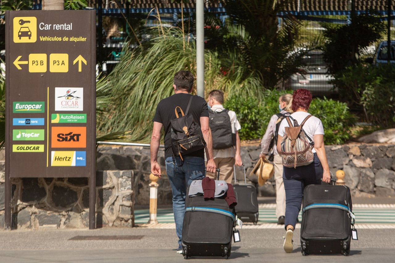 People walk with their luggage upon their arrival to the Reina Sofia Tenerife-South airport on the Canary Island of Tenerife on October 31.