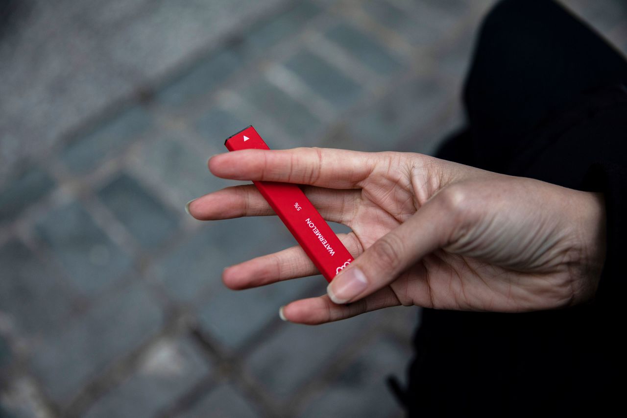 In this 2020 photo a woman holds a flavored disposable vape device in New York.