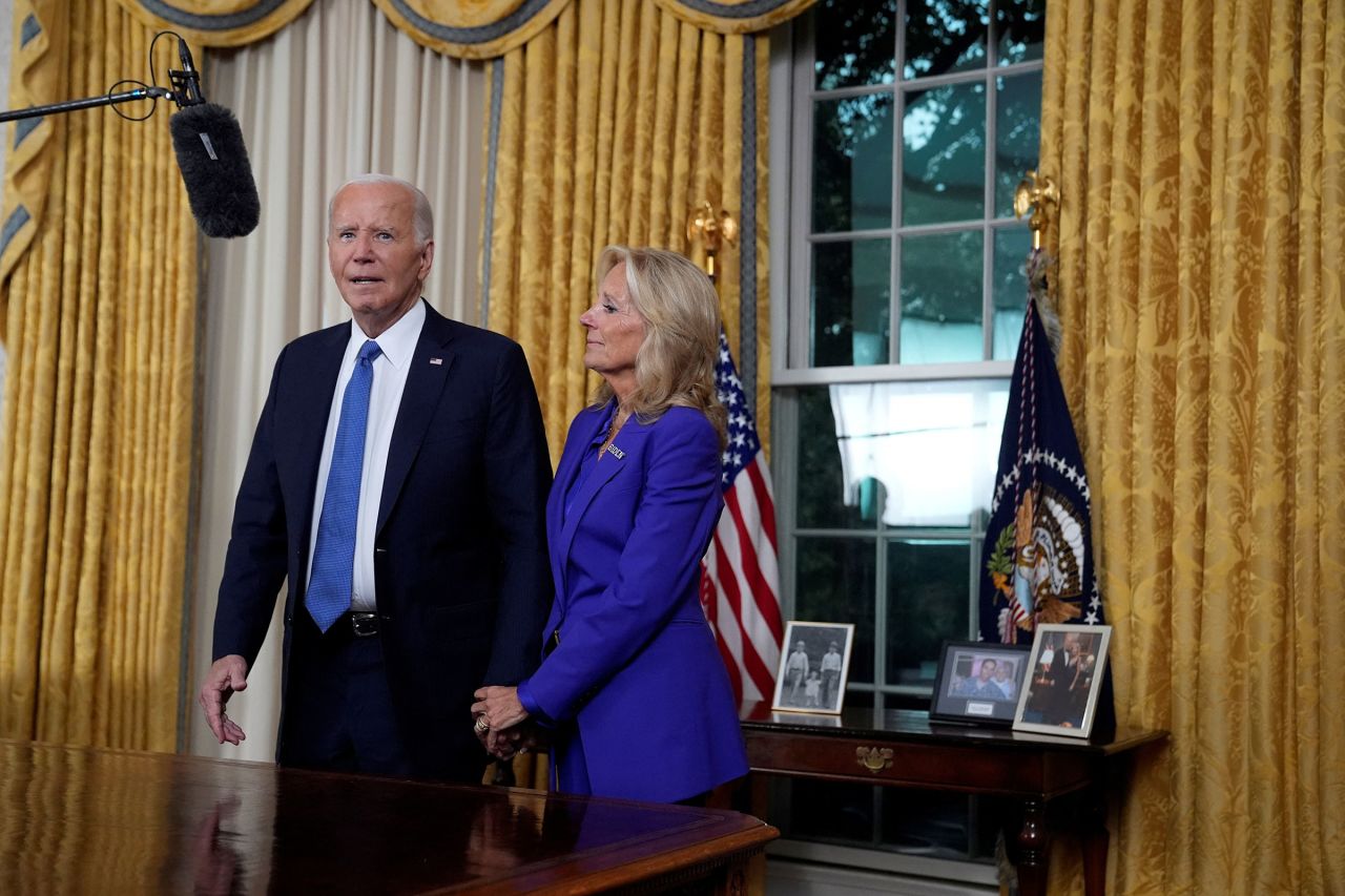 President Joe Biden stands next to first lady Jill Biden as he thanks the camera crew after addressing the nation from the Oval Office of the White House in Washington, DC, on Wednesday, July 24, about his decision to drop his Democratic presidential reelection bid. 