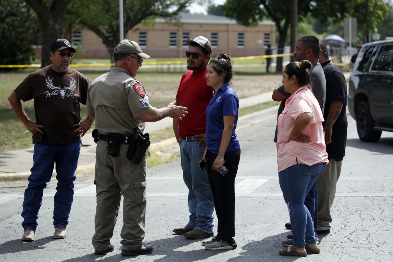  A police officer talks to people asking for information outside the Robb Elementary School in Uvalde, Texas, on May 24. 