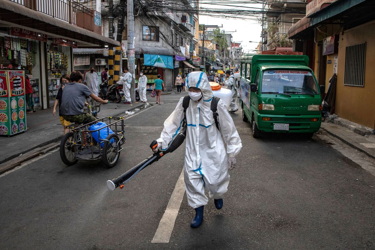 A worker sprays disinfectant along a street in San Juan, Metro Manila, Philippines on March 23.