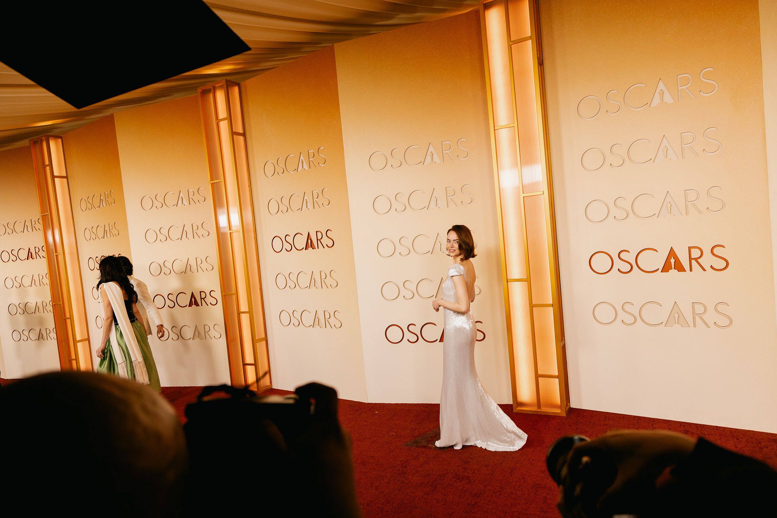 Emma Stone’s floor-length white Louis Vuitton gown, with an elegant plunging back, shines on the red carpet.