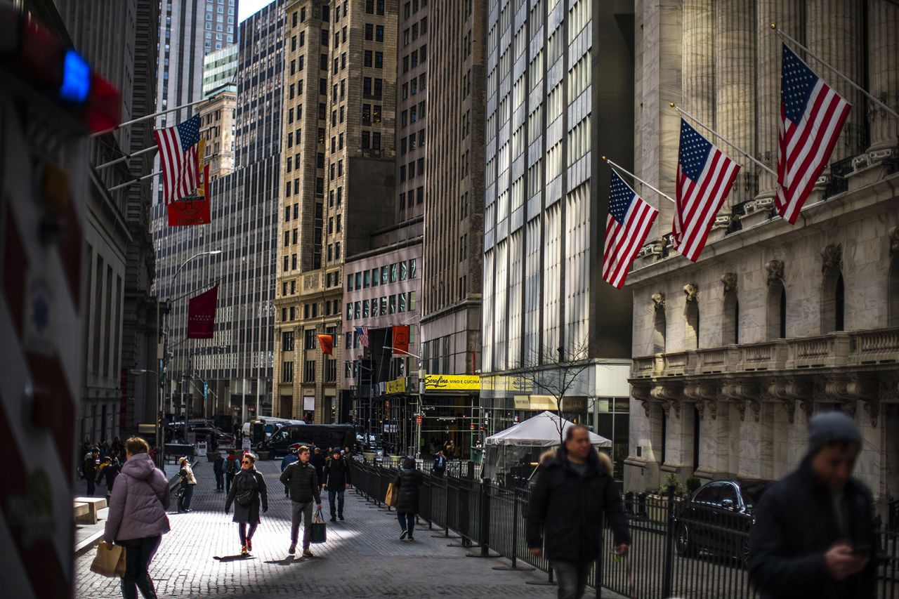 People walk around the New York Stock Exchange in New York, Tuesday, March 19.