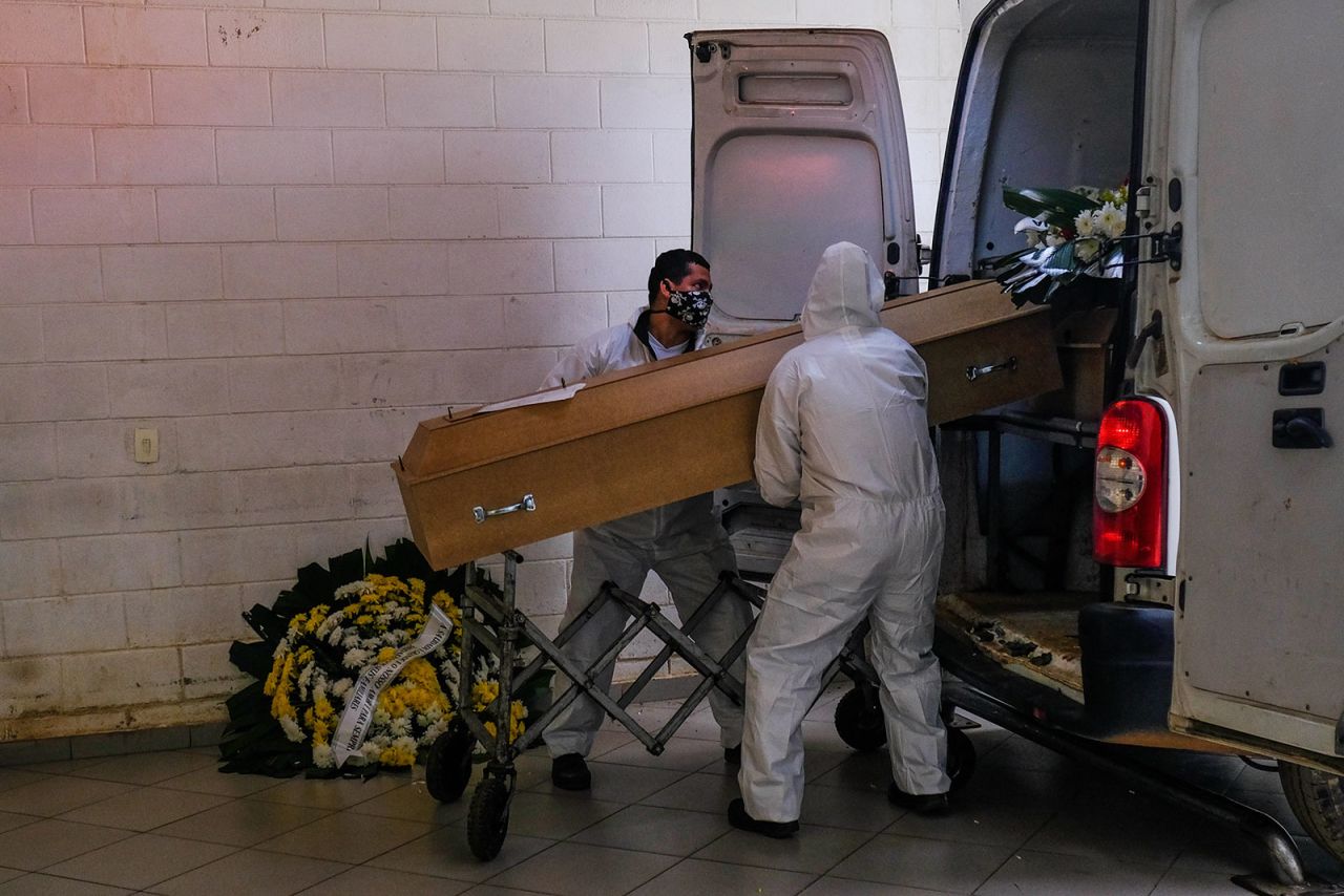 Employees at the Vila Formosa cemetery unload a coffin from a van in San Paulo, Brazil, on May 23.