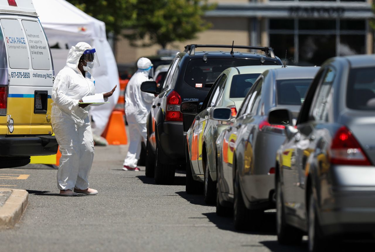 Medical workers take down personal information from those driving in at a Coronavirus testing location in the Cambridge Health Alliance Testing Tent in Cambridge, Massachusetts, on June 18.