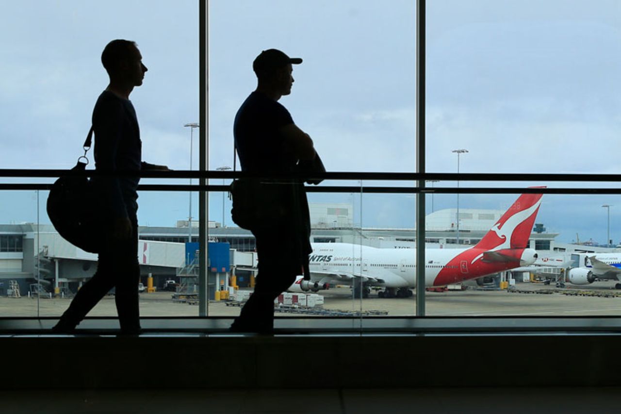 Two passengers walk past a Qantas jet at the International terminal at Sydney Airport on March 10, in Sydney, Australia. 