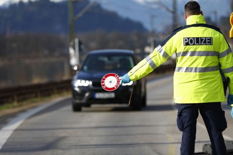 A police officer halts traffic on Germany's border with Austria to check drivers' paperwork in Kiefersfelden, Germany, on March 17.