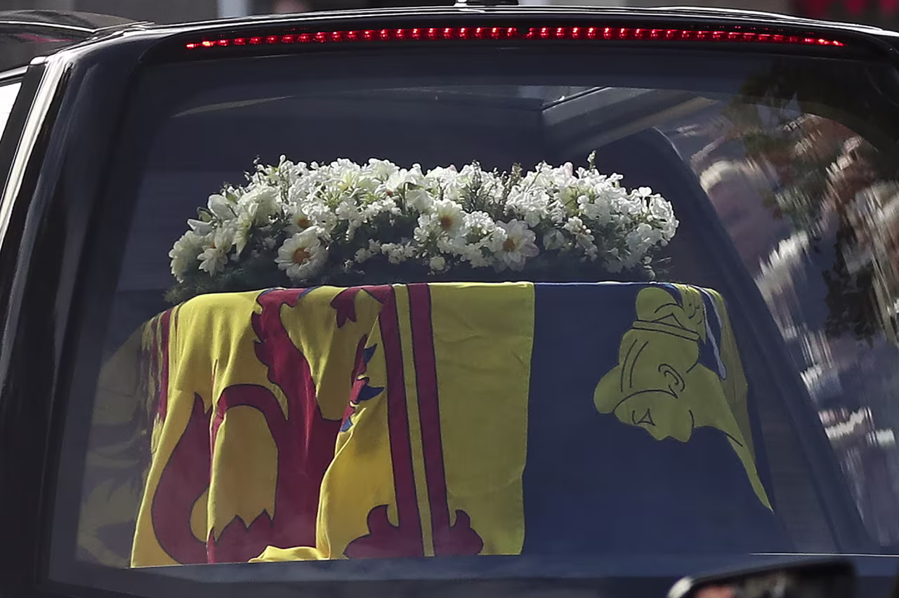 The Queen's coffin is draped in the Royal Standard of Scotland and a wreath of flowers.