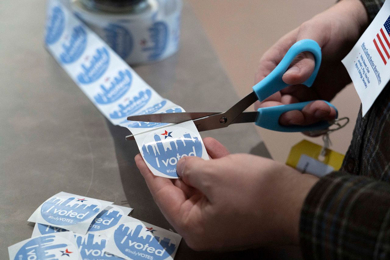 A volunteer cuts "I Voted" stickers on Tuesday at Chin Christian Church in Indianapolis. 