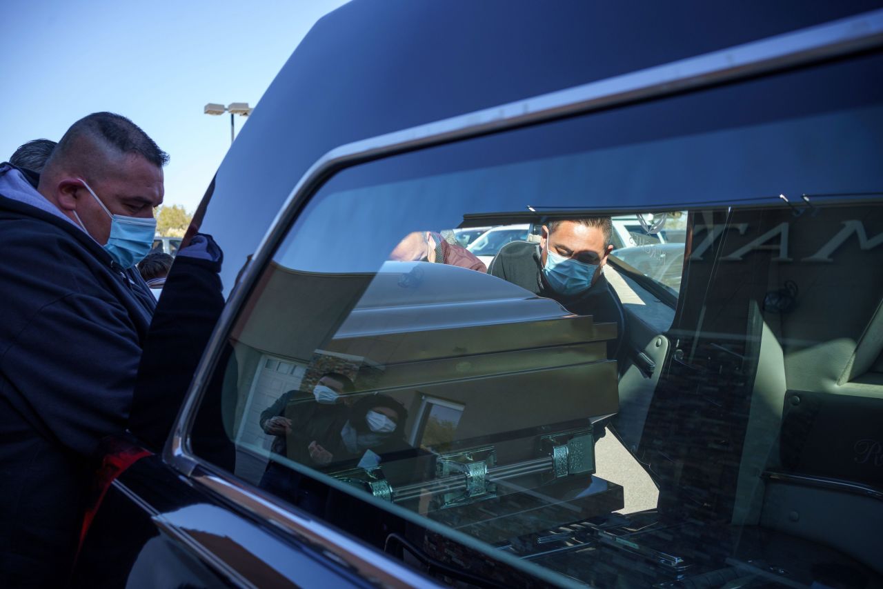 Family and friends place the casket of Humberto Rosales, who died from Covid-19 complications, into a hearse at Perches Funeral Home West in El Paso, Texas, on December 3.