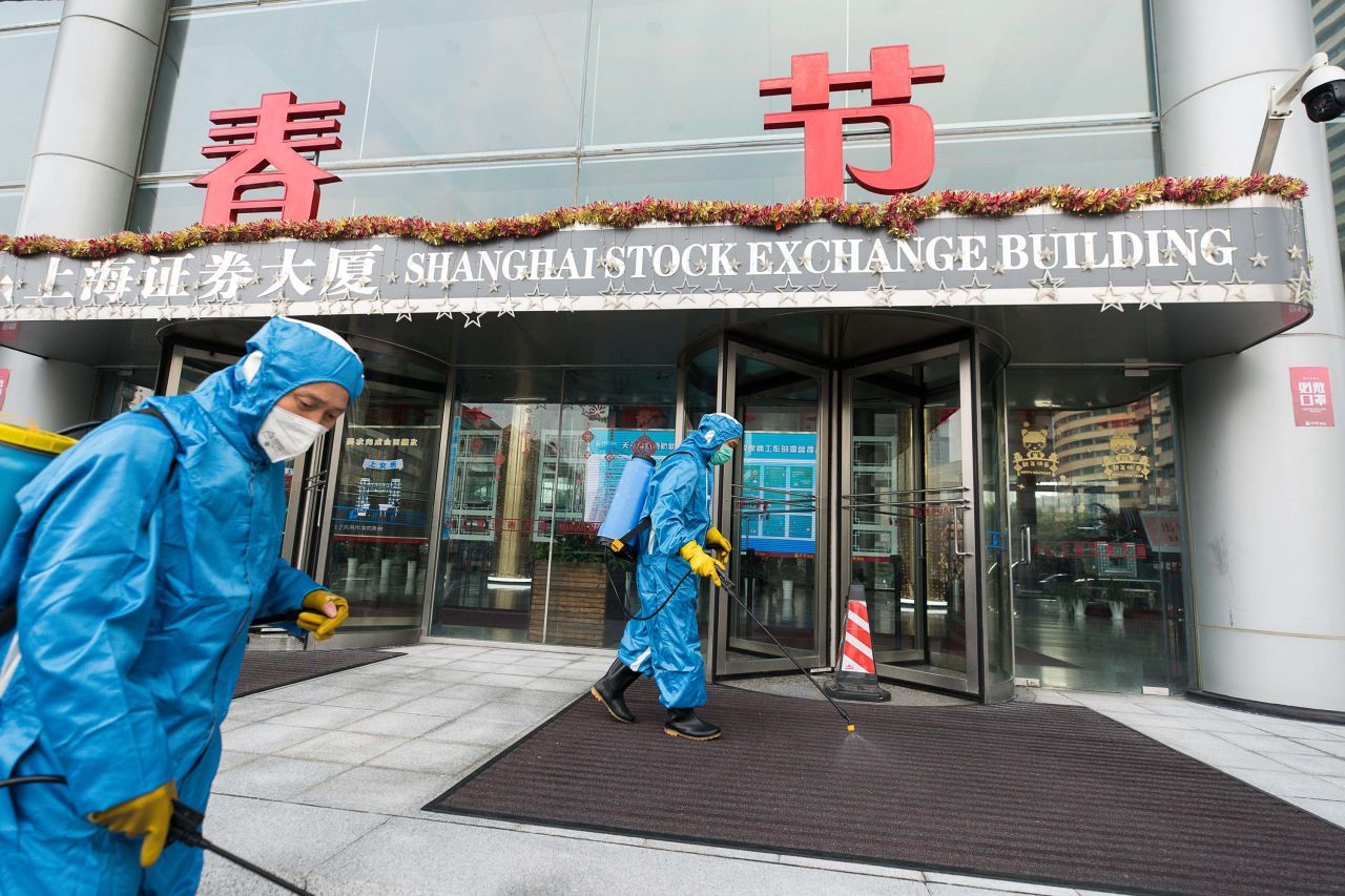 Medical workers spray antiseptic outside the Shanghai Stock Exchange Building on Monday.