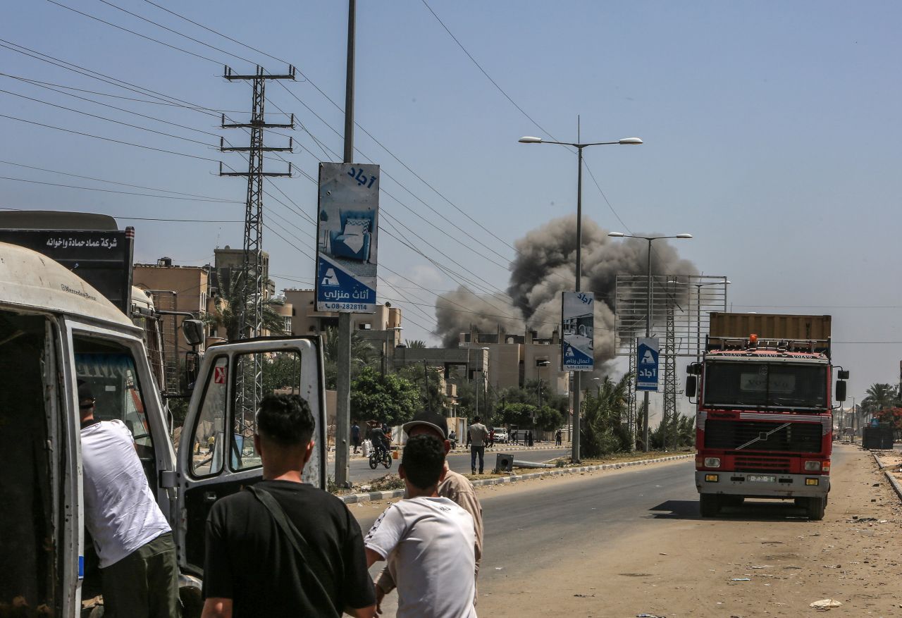 Palestinians watch smoke rise following Israeli attacks on Deir al-Balah, Gaza, on Saturday, June 8.