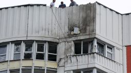 Men are seen on the roof of a damaged multi-story apartment block following a drone attack in Moscow on May 30.