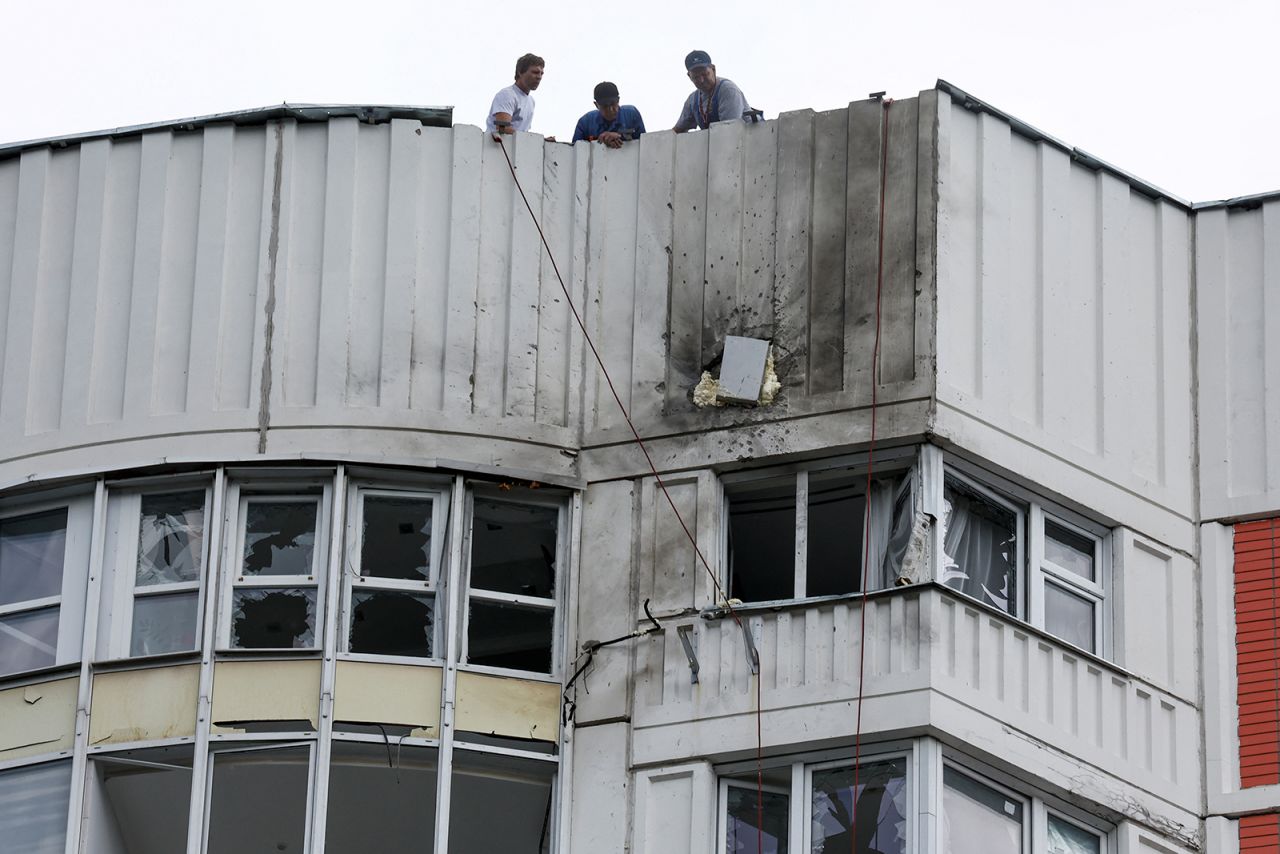 Men are seen on the roof of a damaged multi-story apartment block following a drone attack in Moscow on May 30.