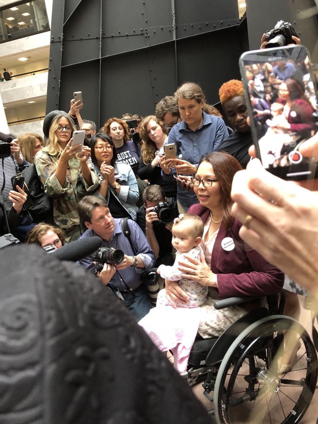 Sen. Tammy Duckworth and her infant daughter, Maile Pearl Bowlsbey, meet with protesters.