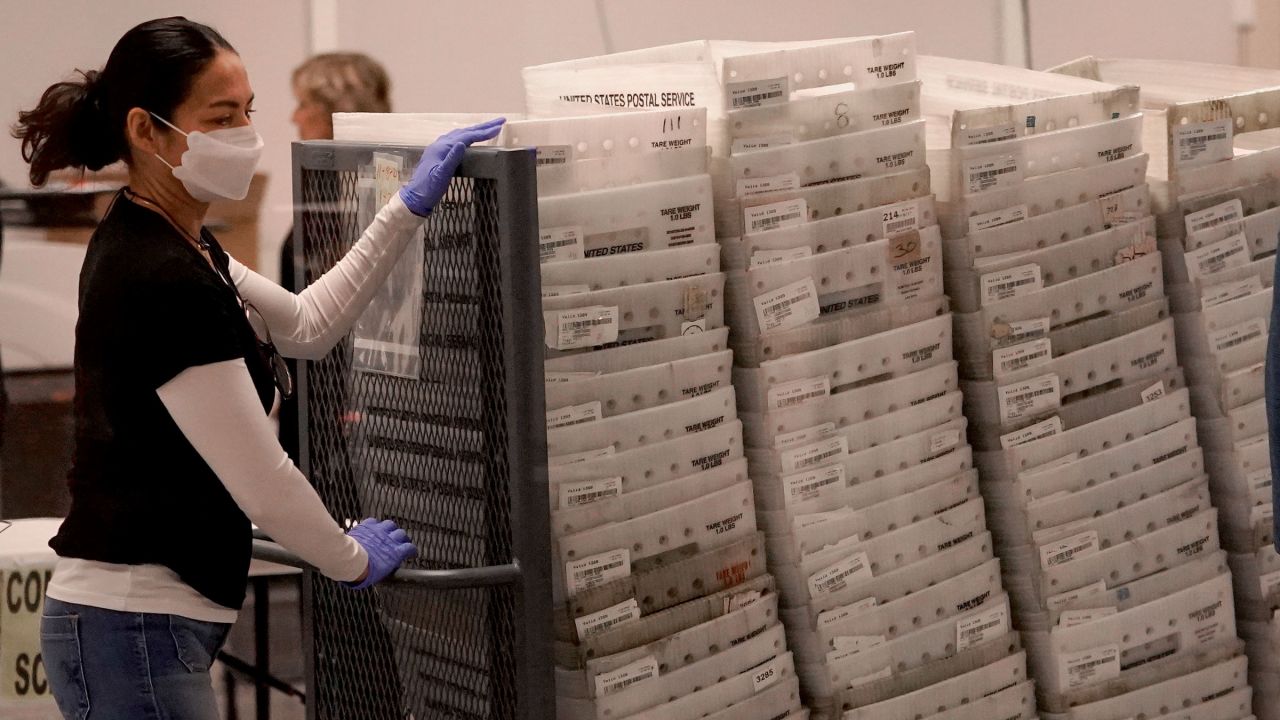 An election worker arrives with ballots to be tabulated Wednesday inside the Maricopa County Recorders Office in Phoenix.